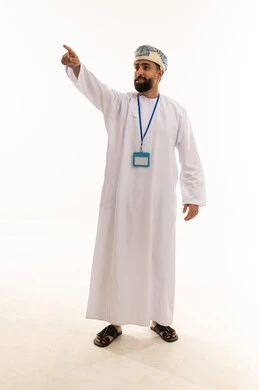 رجل عماني بالزي التقليدي يشير أمام خلفية بيضاء