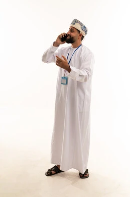 رجل عماني بالزي التقليدي يتحدث في الهاتف المحمول