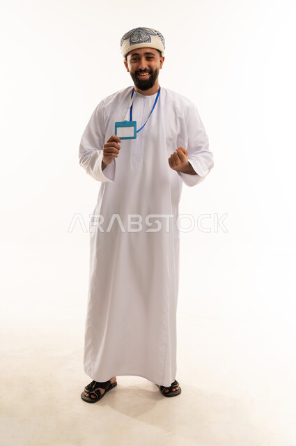 رجل عماني بالزي التقليدي يمسك بطاقة تعريفية