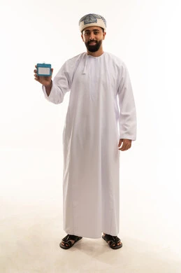 رجل عُماني بالزي التقليدي يحمل بطاقة تعريفية