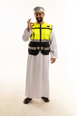 رجل عماني بسترة السلامة يشير بعلامة التمام