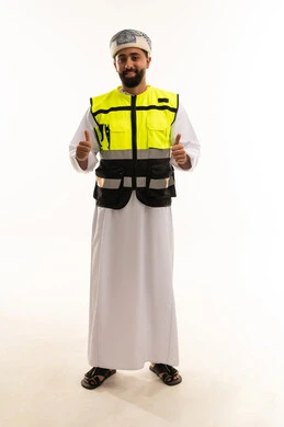 رجل عماني يرتدي سترة سلامة ويشير بالإعجاب