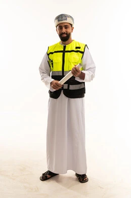 مهندس عُماني بسترة السلامة يمسك مخططاً هندسياً