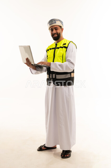 مهندس عماني بجهاز كمبيوتر محمول وسترة سلامة