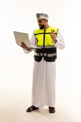 مهندس عماني بجهاز محمول يرتدي سترة السلامة
