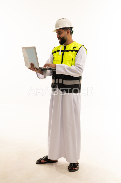 مهندس سعودي مع كمبيوتر محمول يرتدي ملابس السلامة