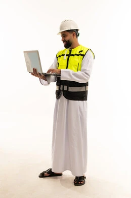 مهندس سعودي مع كمبيوتر محمول يرتدي ملابس السلامة