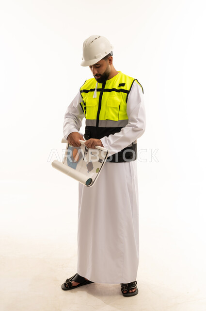 Arab Engineer in Thobe Examining Blueprints