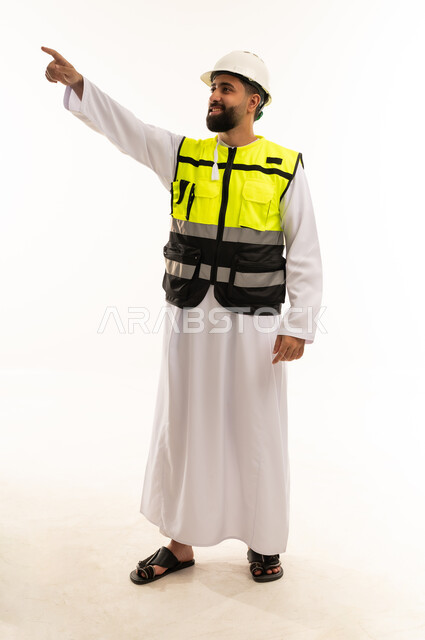 مهندس سعودي بملابس السلامة يشير إلى مسافة