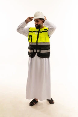 مهندس عربي يرتدي سترة السلامة والخوذة في الاستوديو