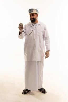 طبيب عماني يرتدي معطفاً أبيض ويمسك بسماعة طبية