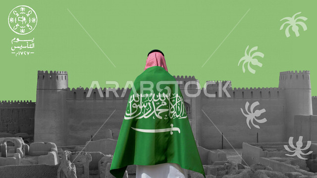 A picture from the back of a Saudi Arabian Gulf man holding the Saudi flag and in front of him the historical archaeological buildings in Saudi Arabia, the old Diriyah in the city of Riyadh, the anniversary of the founding of the Saudi state, the slogan o