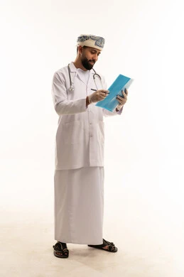 Omani Male Doctor Writing in Medical File Omani Male Doctor Writing in Medical File