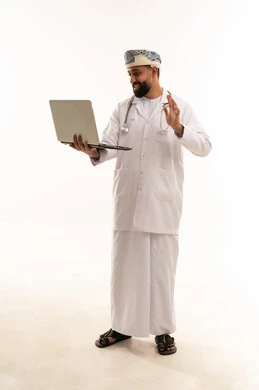 طبيب عُماني يحمل كمبيوتر محمول بخلفية بيضاء