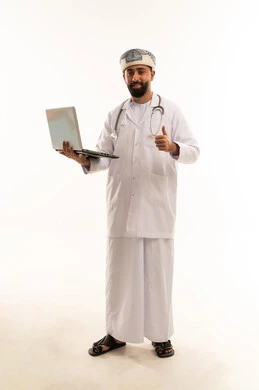 طبيب عماني يحمل كمبيوتر محمول ويشير بالإبهام