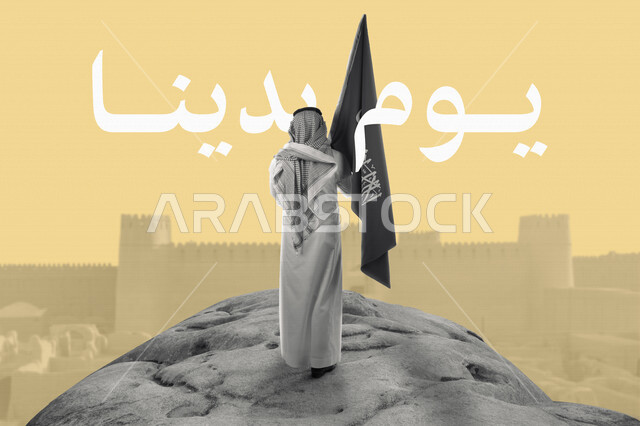 صورة من الخلف لرجل عربي خليجي سعودي يحمل علم السعودية وامامه المباني الأثرية التاريخية في السعودية، الدرعية القديمة في مدينة الرياض، ذكرى تأسيس الدولة السعودية، شعار يوم التأسيس، يوم بدينا