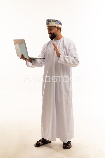رجل عماني يلوح خلال مكالمة فيديو باللابتوب