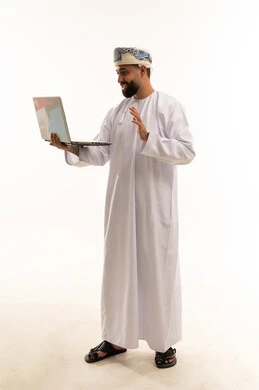 رجل عماني يلوح خلال مكالمة فيديو باللابتوب