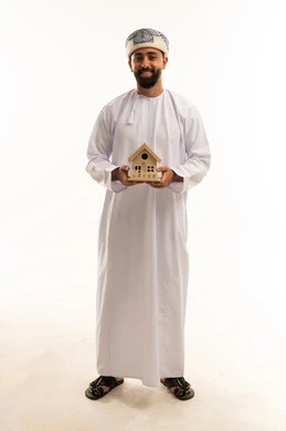 Omani Man Holding House Model on White Background Omani Man Holding House Model on White Background