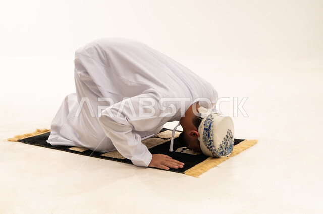 Omani Man Praying Sujud on Rug in Studio