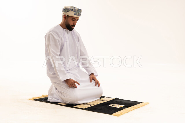 Omani Man Praying on Mat White Background