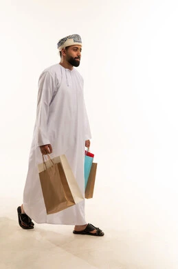 رجل عُماني يحمل أكياس تسوق في الاستوديو