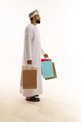رجل عماني يحمل أكياس تسوق بخلفية بيضاء