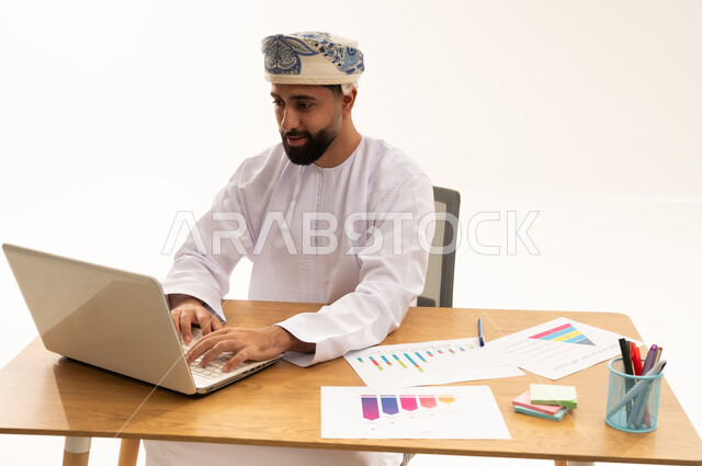 Omani Businessman Working on Laptop at Office Desk