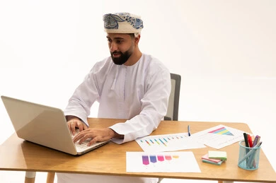 رجل أعمال عماني يعمل على الكمبيوتر المحمول