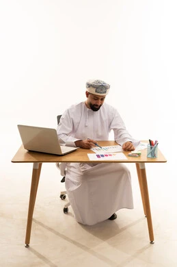 رجل أعمال عماني يحلل الرسوم البيانية على المكتب