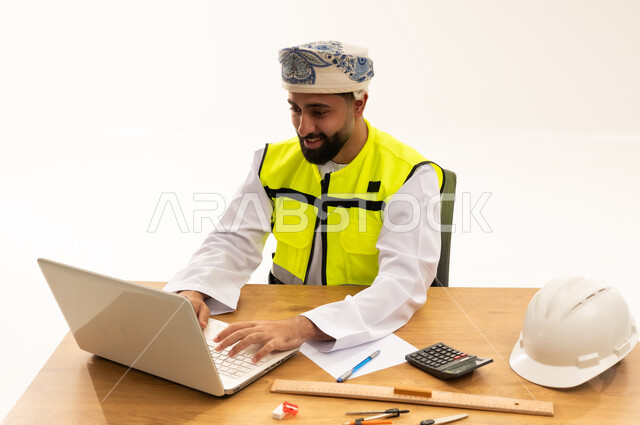 مهندس عُماني يعمل على كمبيوتر محمول في المكتب