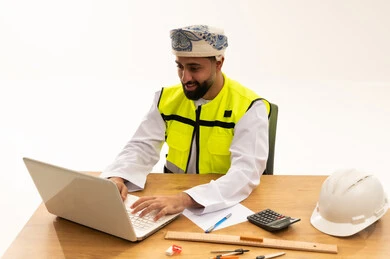 مهندس عُماني يعمل على كمبيوتر محمول في المكتب