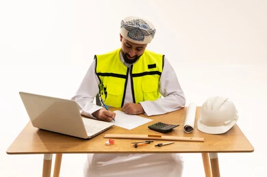 مهندس عماني يعمل على مكتبه مع أدوات هندسية