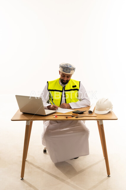 مهندس عماني على مكتب العمل مع أدوات السلامة