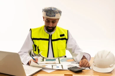 مهندس معماري عماني يراجع مخططات البناء في المكتب
