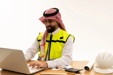 مهندس سعودي يستخدم الكمبيوتر المحمول في المكتب