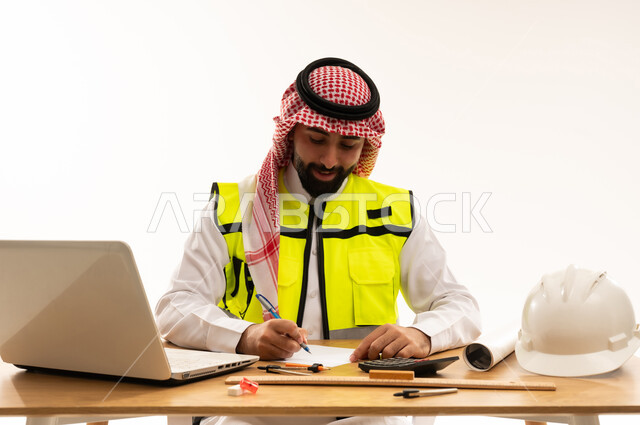 مهندس سعودي يعمل في المكتب مع سترة السلامة