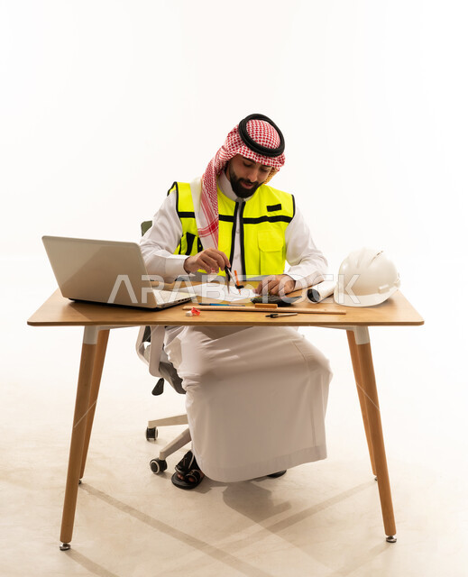 Arab Engineer Working at Desk with Laptop and Tools
