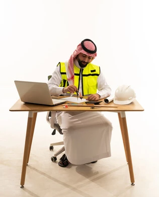Arab Engineer Working at Desk with Laptop and Tools