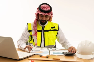 مهندس سعودي يراجع مخططات هندسية على مكتبه