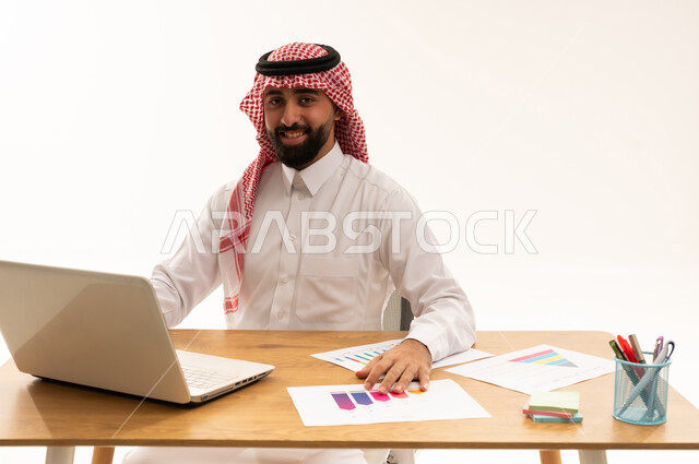 رجل أعمال سعودي في المكتب مع كمبيوتر محمول