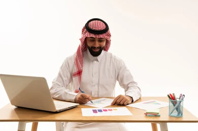 رجل أعمال سعودي يعمل على الحاسوب والرسوم البيانية