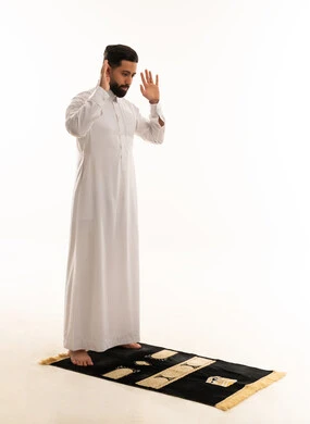 رجل سعودي يؤدي الصلاة بخلفية بيضاء رجل سعودي يؤدي الصلاة بخلفية بيضاء