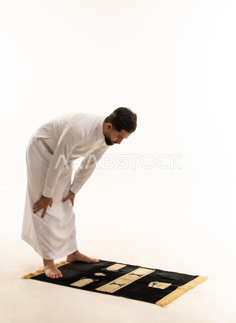 رجل سعودي بالثوب التقليدي يؤدي وضعية الركوع
