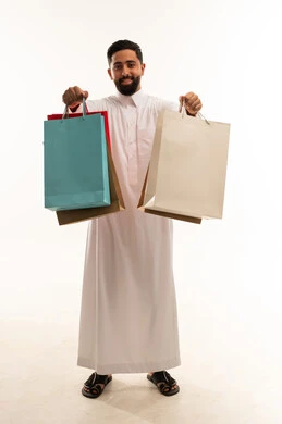 رجل سعودي يحمل أكياس تسوق على خلفية بيضاء