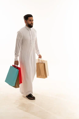 رجل سعودي بالثوب يحمل أكياس تسوق