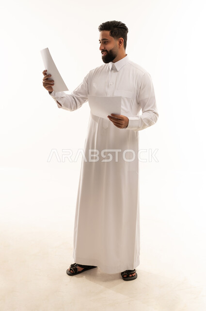 Saudi Man in Thobe Reviewing Documents in Studio