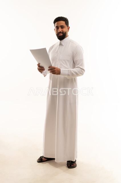 رجل سعودي بالثوب الأبيض يحمل ورقة رسمية