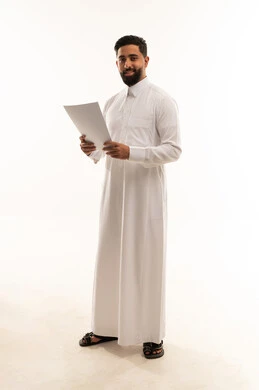 رجل سعودي بالثوب الأبيض يحمل ورقة رسمية