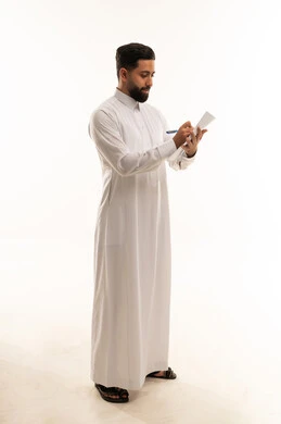 Saudi Man in White Thobe Writing on Notepad Studio